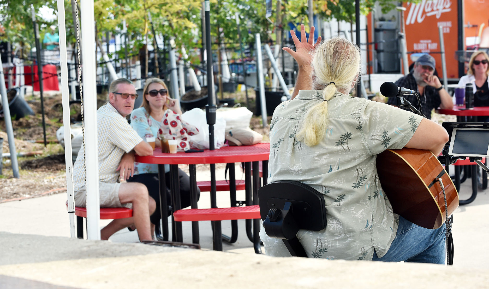 Rick Venn of The Rotten Bros. tells a story between songs at Sunday's farmers market at Milaeger's